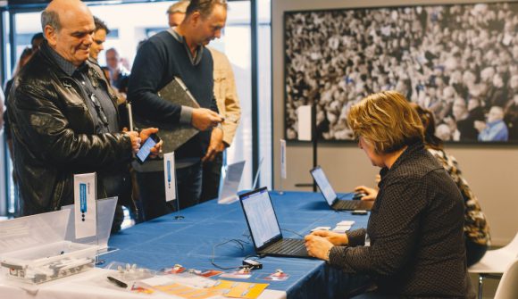 mensen staan bij een bureau tijdens de instapdag