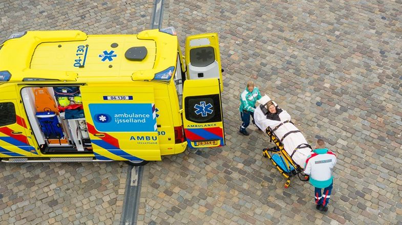 Ambulancepersoneel plaatst een persoon op een brancard in de ambulance